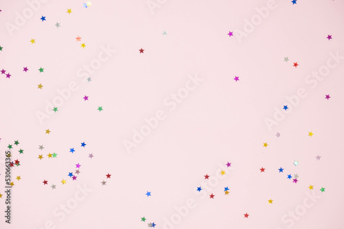 small shiny stars of candy on a pink background with a place for the text mockup, the concept of the new year
