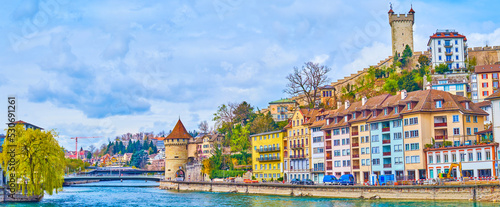 Panorama of Reuss river's townhouses and medieval towers on Museggmauer walls on the hill, Lucerne, Switzerland