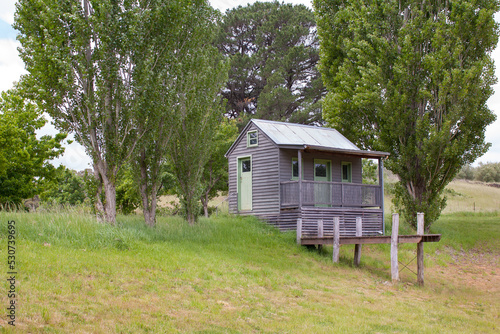 Daylesford, Victoria / Australia - November 1 2014: Side view of an inviting and charming small home surrounded by trees and nature at Lavandula lavender Farm. Isolated off-grid tiny house concept. 