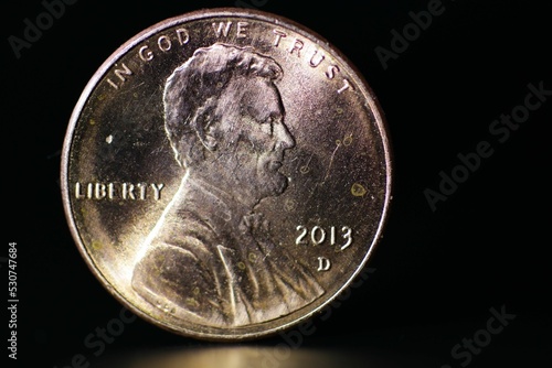 Closeup of In God We Trust Lincoln coin isolated on a black background