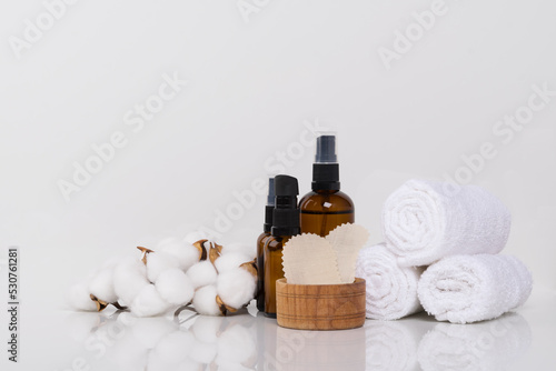 on a white background, oil for massage and spa treatments and towels wrapped in a roll