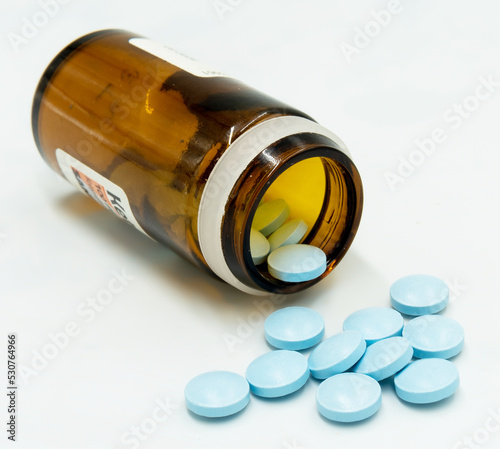 Butelka z rozsypanymi niebieskimi tabletkami