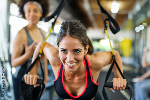 Beautiful women working out in gym together to stay healthy. Sport, people, friend concept.