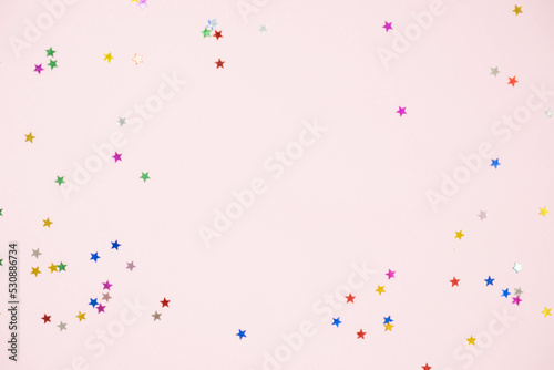 small shiny stars of candy on a pink background with a place for the text mockup, the concept of the new year
