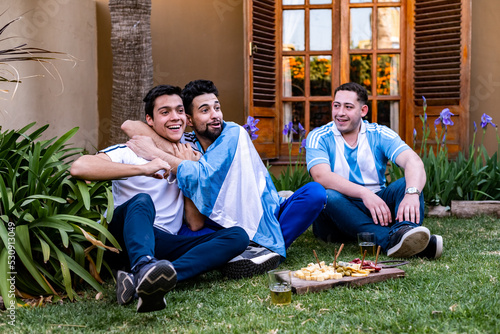 hinchada celebrando el gol del mundial de futbol, ​​afectando, llorando de la alegria . Con picadas y cervezas, los colores celeste y blanco, luz natural, riendo, gol