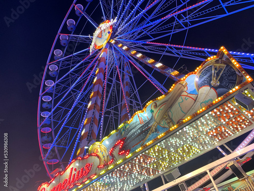 ferris wheel at a fair near nach. colorful lighting