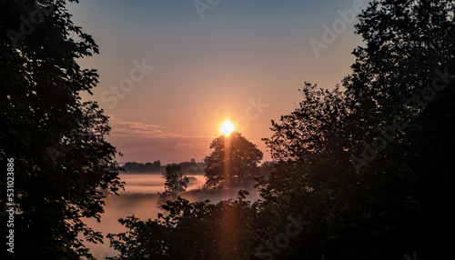 Wschód słońca w wiejskim obszarze zachodniej Polski, w porze wiosennej, okolica spowita mgłami, złote barwy