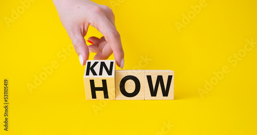 Know how symbol. Businessman hand turnes wooden cubes and changes word How to Know. Beautiful yellow background. Business and Know how concept. Copy space.