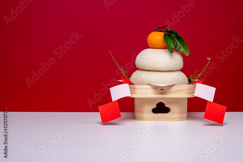 本物のお餅“鏡餅"を右側に配置した写真 紅白背景 低い三宝(台座)あり