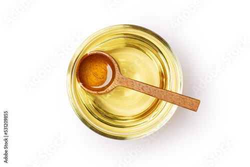 Soybean oil or vegetable cooking oil in glass bowl with wooden spoon isolated on white background with clipping path.