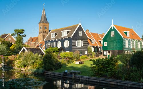 Dutch touristic village of Marken, view of the church tower and wooden houses along the canal