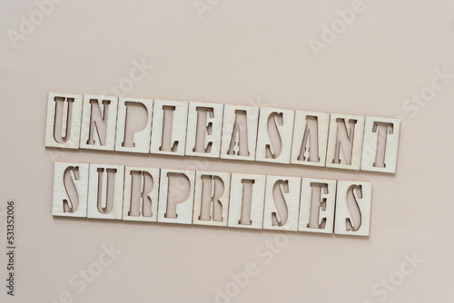 unpleasant surprises - sign with wood type