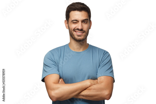 Handsome young man in blue t-shirt, with crossed arms smiling and winking, looking at camera