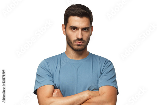 Young man in blue t-shirts tanding with arms crossed and serious concentrated face at camera, looking aggressive