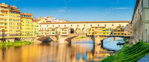 Panorama of beautiful medieval bridge Ponte Vecchio over Arno River, Florence, Italy. Architecture and landmark of Florence. Travel concept background.
