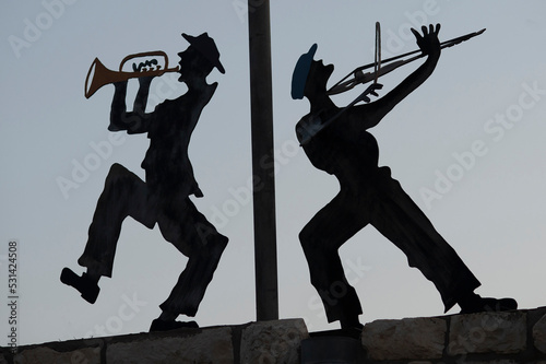Silhouette metal cutouts of dancing Orthodox Jewish men on a rooftop in northern Israel.