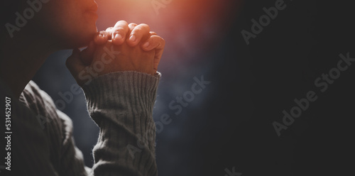 Christ religion and christianity worship or pray concept. Christian catholic woman are praying to god in dark at church. Prayer person hand in black background. Girl believe and faith in jesus christ.