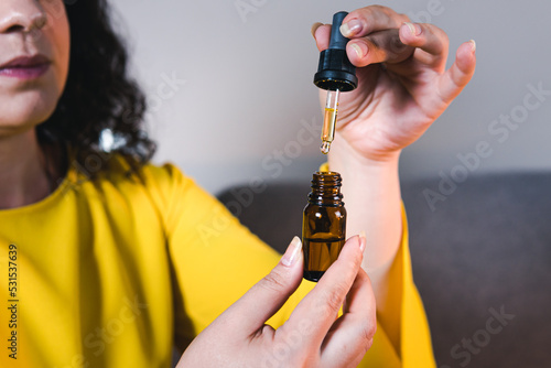 Adult woman using and holding medical cannabis oil. CBD. Concept of herbal and alternative medicine