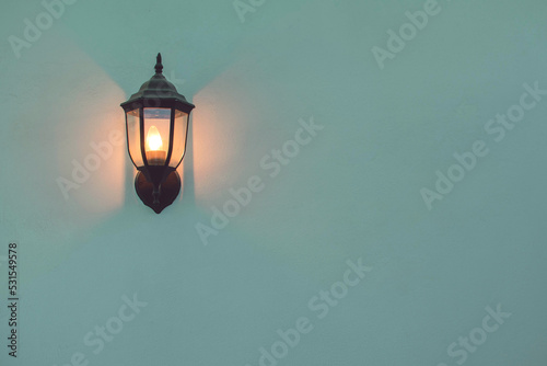 Pared con lampara antigua o faro con luz calida y amplio espacio a la derecha 
