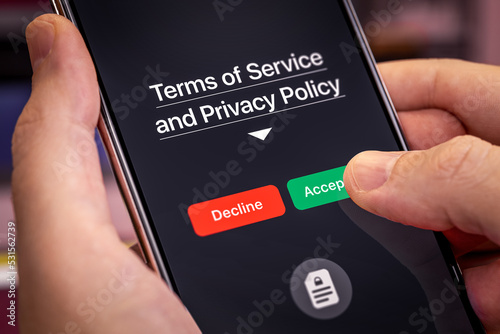 Smartphone user agrees to accept Terms of Service and Privacy Policy mobile app. Finger touches the Accept button. Dark app interface with Accept and Decline buttons