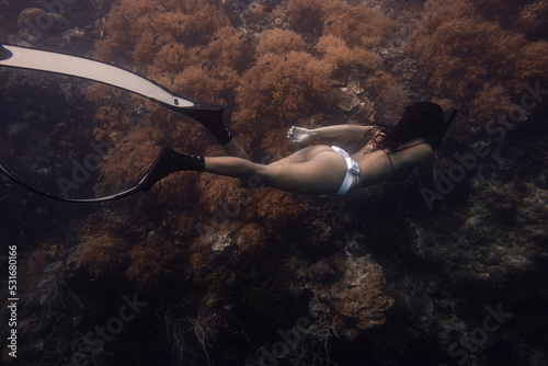 Female freediver fun diving in the ocean sea holding breath