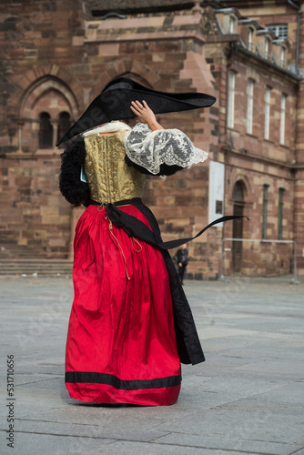 Strasbourg - France - 17 September 2022 - Portrait on back view of woman wearing a traditional medieval costume walking in the street