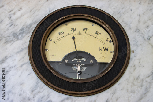 A circular dial showing the current state of electricity consumption on a historical wattmeter