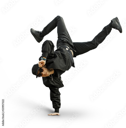 Fashion handsome man dancer with stylish baseball cap and sunglasses in a fashionable black outfit with a bomber jacket, jeans and sneakers performs and stands on hand. Dance boy