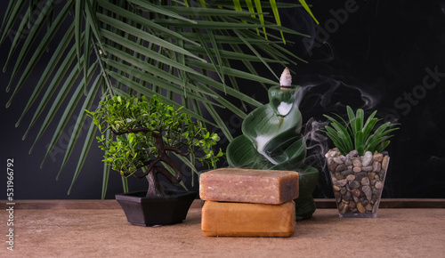 zen concept - incense smoke flowing and soaps with bonsai tree