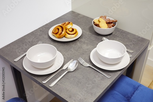 Stół w nowoczesnej stylowej kuchni w apartamencie z talerzami i ciasttkiem