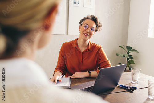 Happy hiring manager interviewing a job candidate in her office