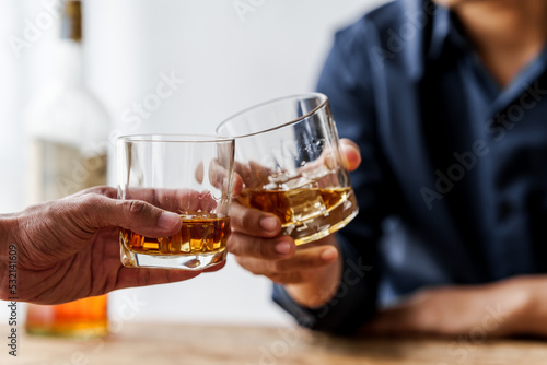 Sad depressed addicted drunk guy, Alone asian man drinker alcoholic sitting at bar counter with glass drinking whiskey.