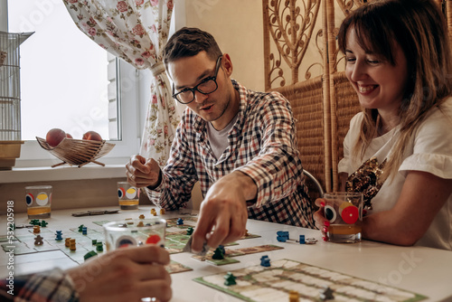 A group of young people play board games at home in the kitchen.Time together.Stay home,board games concept.Selective focus.