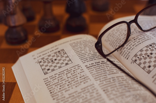 Self studying chess from a book, wooden chessboard and chess pieces