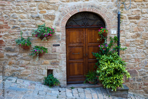 Italy, Tuscany, Volterra. Homes along a street surrounded by flower pots in the medieval town of Volterra.