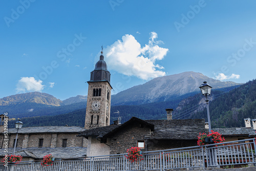 View of the Bell Tower, some Houses and the Panorama with the Mountains Behind in Morgex in Aosta Valley, Italy