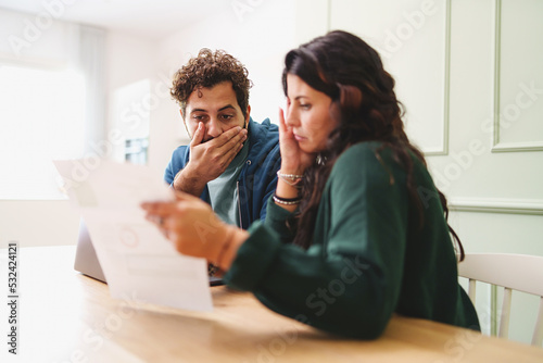 A young married couple is worried looking at the electricity bill or the arrival of very expensive taxes