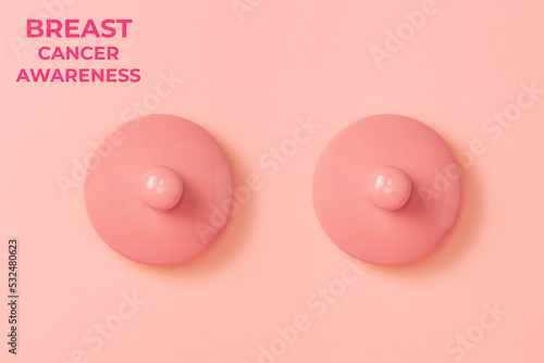 Two pink ceramic lids on a pink background symbolizing the female breast. Flat lay. Concept of Breast Cancer Awareness Month