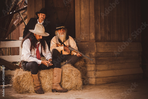 Cowboys group under conversation hand holding gun or rifle weapon ,this is vintage western lifestyle 1800s. cowboy town. 
