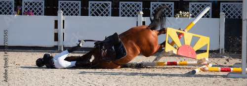 A rider falls from a horse during a show jumping competition. An equestrian accident. The rider and horse were not injured.