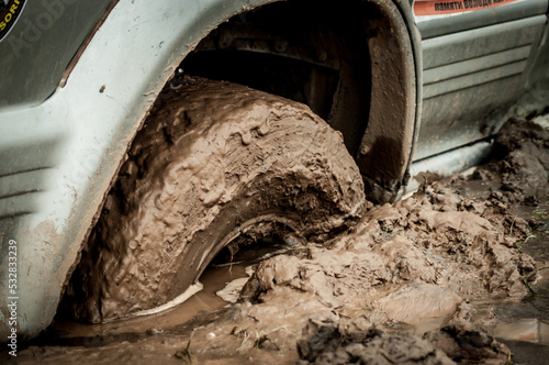 Car wheel stuck in mud, motorsport, mud tire testing. Off-road driving, car breakdown. Emergency evacuation.