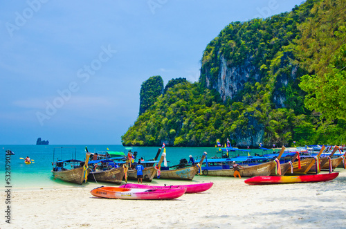 Thai traditional wooden longtail boat and beautiful sand beach at Koh Hong island in Krabi province, Thailand.
