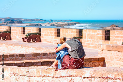 Woman resting on top walls of Essaouira city of Morocco - Wall of an ancient castle Sqala mogador historic city medina of Essaouira, Morocco