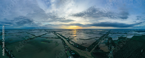 Aerial sunrise panorama view of colorful Mekong Delta over water and agricultural land in Vietnam.