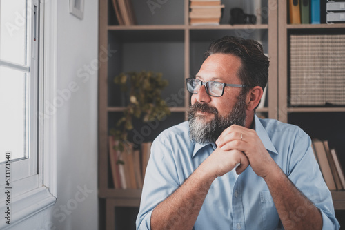 Caucasian reflexive looking at laptop screen, reflexing on work, businessman independent working in a difficult project. Male person preparing at home in the office indoor..