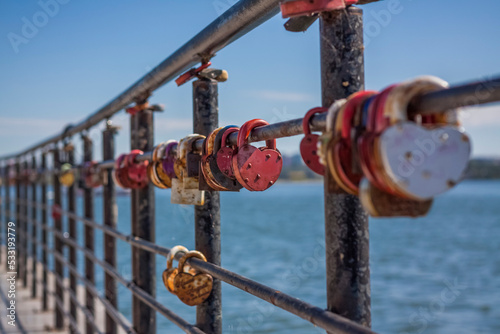 A heart-shaped door lock, a symbol of love and fidelity with a lake in the background, hangs on the fence of the bridge. The heart-shaped castle symbolizes loyalty and love