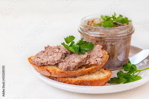 Closeup of sandwich with Duck Terrine on a bread slice. Pâté with Armagnac. White table.