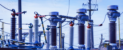 High voltage power transformer substation.High voltage electric power transformers in the blue cloudy sky and trees.Banner.Toned.