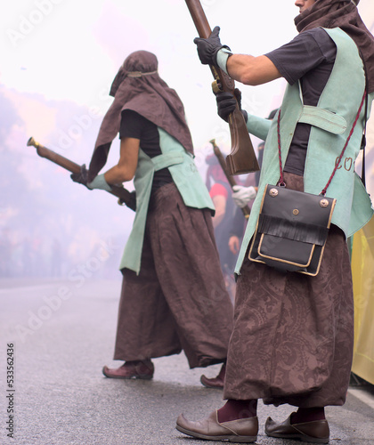 Moors and Christians fest. Two unrecognized people in arabic costume shooting fire gun blunderbuss