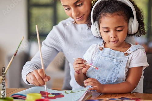 Mother, girl and bonding in painting activity with music headphones, radio or audio for autism help. Brazilian woman, art parent and creative child listening to relax autism podcast in house or home